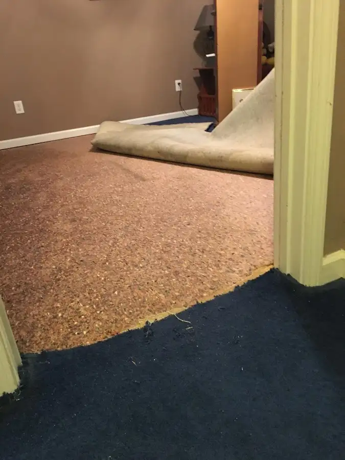 Carpet pad removal revealing water damage during Water Mitigation Services in Jenks